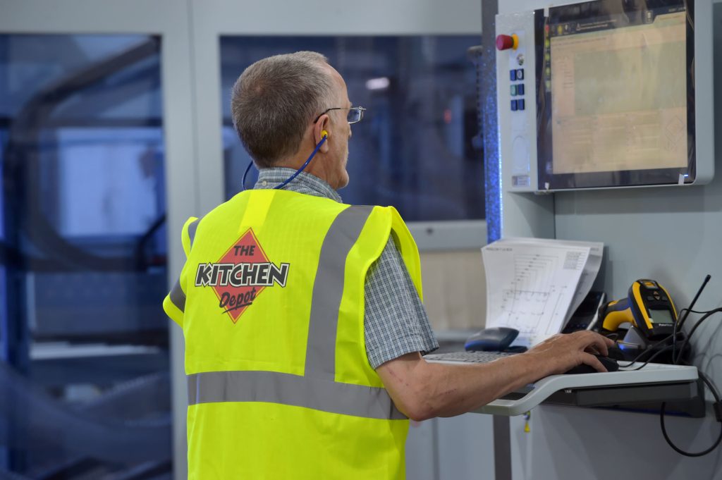 The Kitchen Depot warehouse worker looking at computer. The history of The Kitchen Depot