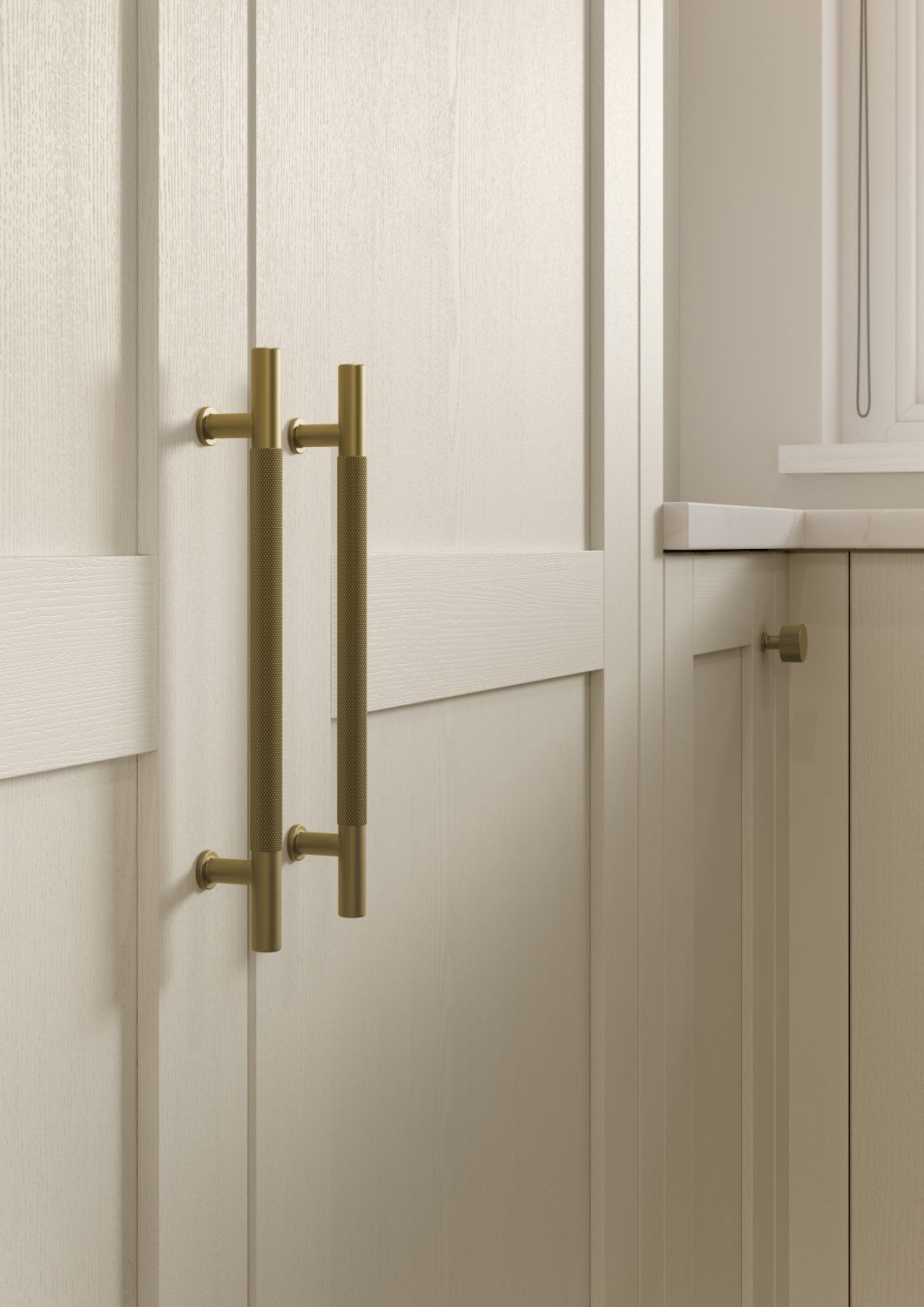 Kitchen with Nola door in Taupe Grey by The Kitchen Depot, featuring an island with bar stools, light cabinetry, and gold accents.